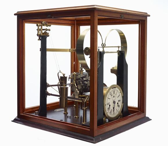Brass instrument in glazed wooden case.
